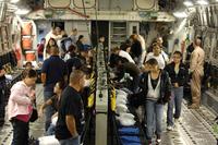 Space-available passengers board a C-17 at Hickam Air Force Base.