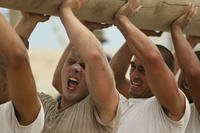 BUD/S candidates participate in strength and conditioning training with logs.